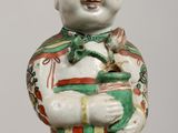 chinese porcelain figurine of a smiling child holding a fish