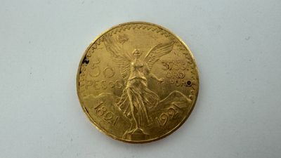 gros plan d'une pièce d'or sur une surface blanche