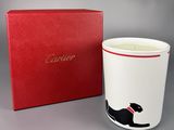 un gros plan d'une tasse ornée d'un chat, à côté d'une boîte