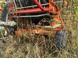 a tractor that is sitting in the grass with a hose attached to the back of it