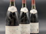 three bottles of wine are lined up on a table