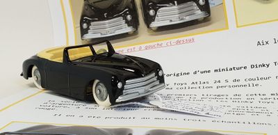 a black toy car sitting on top of a piece of paper
