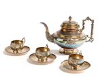 a silver tea pot and two silver cups on a table