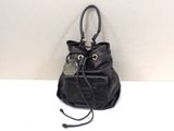 black leather handbag with a tag attached to it on a white surface