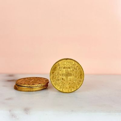 two gold coins sitting next to each other on a marble surface