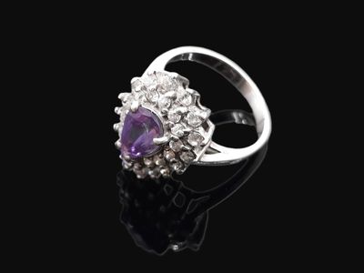 une bague en améthorate et diamant posée sur une surface noire