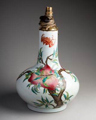 un vase blanc orné d'un oiseau et de fleurs