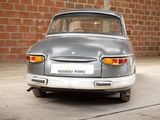 a silver car that is parked in front of a brick wall