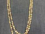 un long collier composé de deux rangées de perles jaunes et blanches