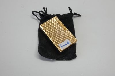 une photo d'un étui à cigarettes doré posé sur un sac noir