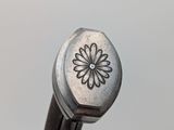 close up of a metal object with a flower on the top of it