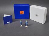 a couple of figurines are standing in front of a blue box