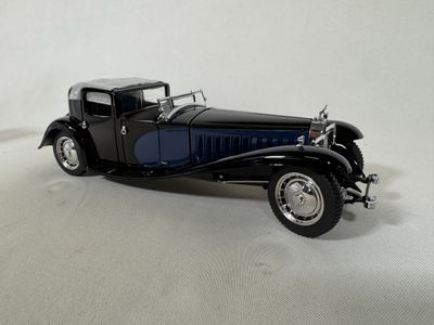 a black model of a car on a white surface