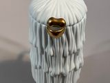 a white and gold figurine of a man with a beard