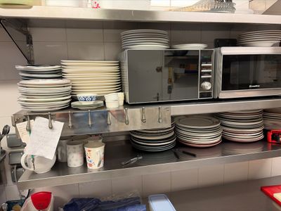 a lot of plates and bowls on the shelf in the kitchen