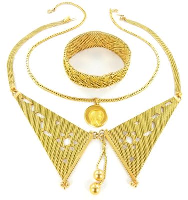 un gros plan d'un collier et d'un bracelet en or sur fond blanc