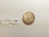 a close up of a coin on a white surface with a price tag