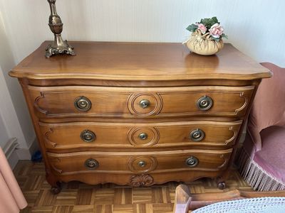 une commode dans une pièce, sur laquelle est posée une lampe