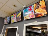 de nombreux téléviseurs accrochés au mur au-dessus du comptoir