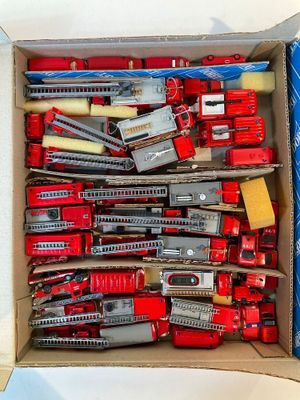 une boîte remplie de petits trains et d'autres véhicules miniatures