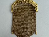 a small gold purse with a chain around it