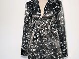 une robe à fleurs noire et blanche posée sur un présentoir pour mannequin