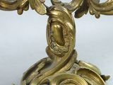 a gold candle holder with a bird on top of it