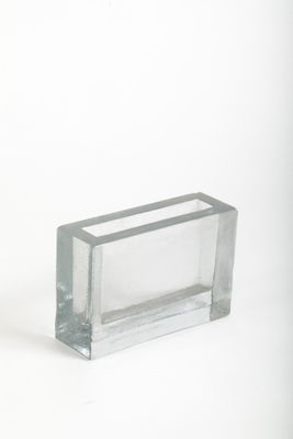 un bloc de verre transparent posé sur une surface blanche