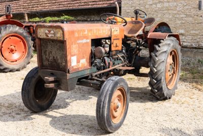un vieux tracteur garé devant un bâtiment