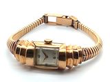 une image représentant une montre-bracelet avec un bracelet en or sur fond blanc