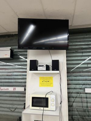 a television mounted on a wall above a microwave