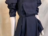 the mannequin is wearing a black dress with ruffled sleeves