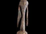 une sculpture en bois représentant une femme debout sur une branche d'arbre