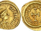 a gold coin with an image of a woman and a cross on it