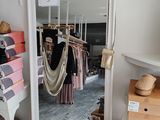 a mirror in the corner of a room that has clothes on hangers