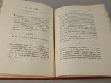 an open book on a table with a red cover