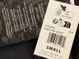 black jacket with a small tag on it sitting on a table