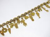 une photo d'un bracelet en or orné de breloques, posé sur un fond blanc
