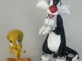deux figurines représentant des insectes et un chat posées sur une table