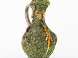 une image représentant un vase vert sur lequel est posé un lézard