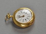 a gold pocket watch with roman numerals on it