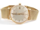 an image of a gold wrist watch with a white dial