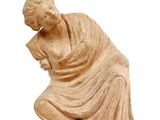 an image of a statue of a woman sitting on a white surface