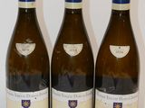 trois bouteilles de vin sont alignées sur une surface blanche