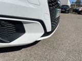 the front end of a white car with a black grill grille