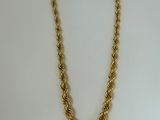 a gold chain necklace with a knot design on a white background