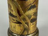 a gold vase with a picture on it on a stand
