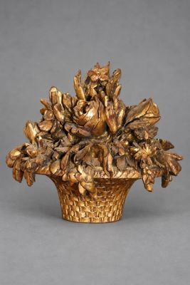 un vase en or contenant des fleurs, posé sur une table