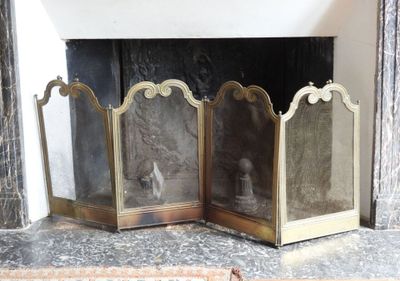 une cheminée avec un foyer et un miroir sur le manteau de cheminée