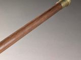 an antique wooden pipe with brass fittings on a white surface